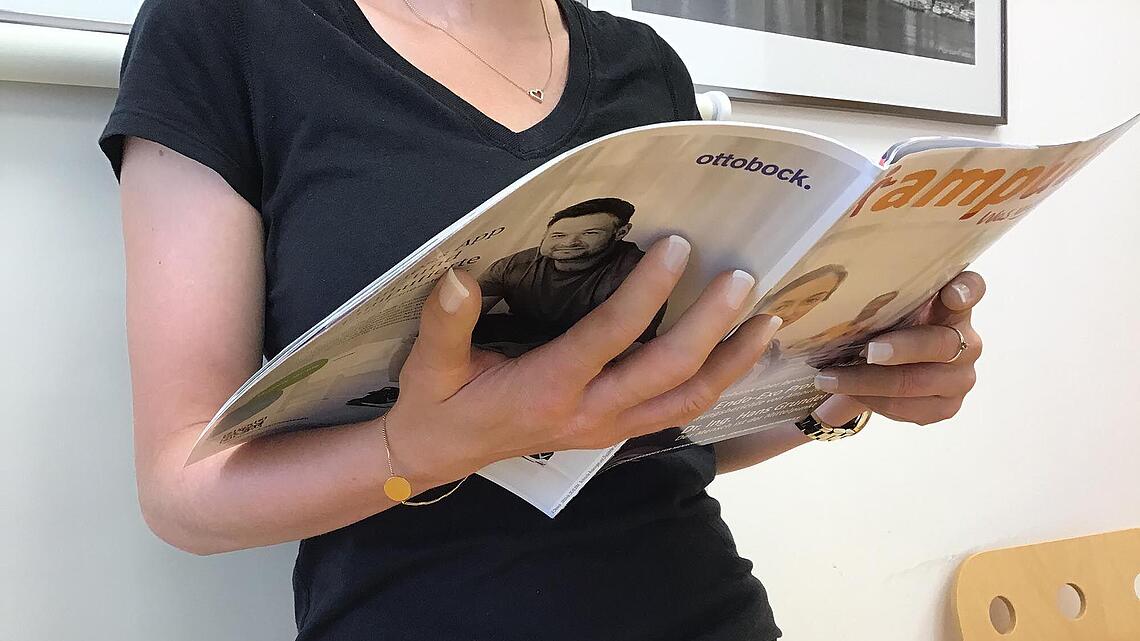 Silikon-Fingerprothesen an der Hand einer Frau die Zeitung liest Silikon-Fingerprothesen an Frau die Zeitung liest