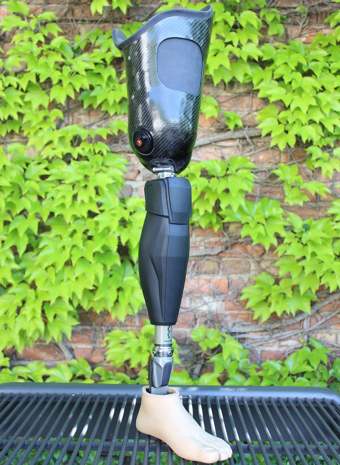 Oberschenkel-Prothese mit Genium-X3-Kniegelenk und Silikon-Innenschaft Oberschenkel-Prothese mit Genium-X3-Kniegelenk und Silikon-Innenschaft stehend vor efeubewachsener Mauer