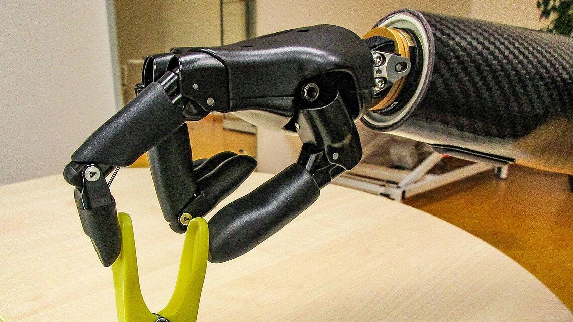Handprothese greift eine Klammer bei Prothesen-Gebrauchsschulung Handprothese greift eine stehende Klammer bei der Prothesen-Gebrauchsschulung