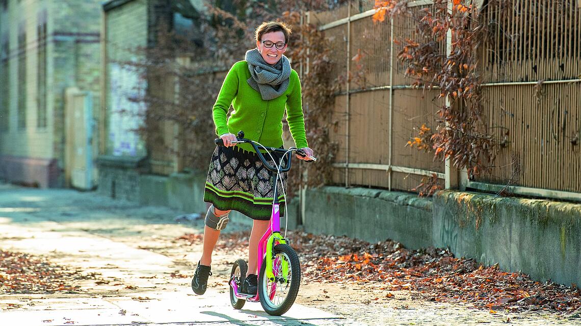 Rollerfahren mit Knie-Manschette, © Ottobock Frau mit Knie-Manschette, die Roller fährt, © Ottobock