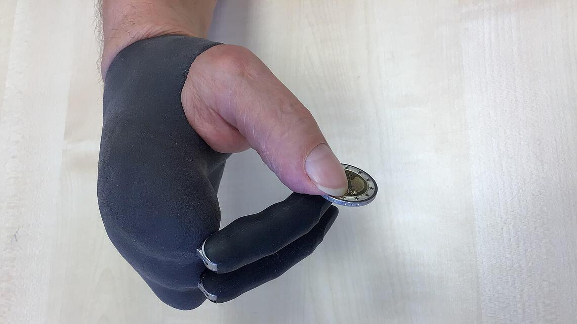 Teilhandprothese mit einer Münze Teilhandprothese, die eine Münze hält