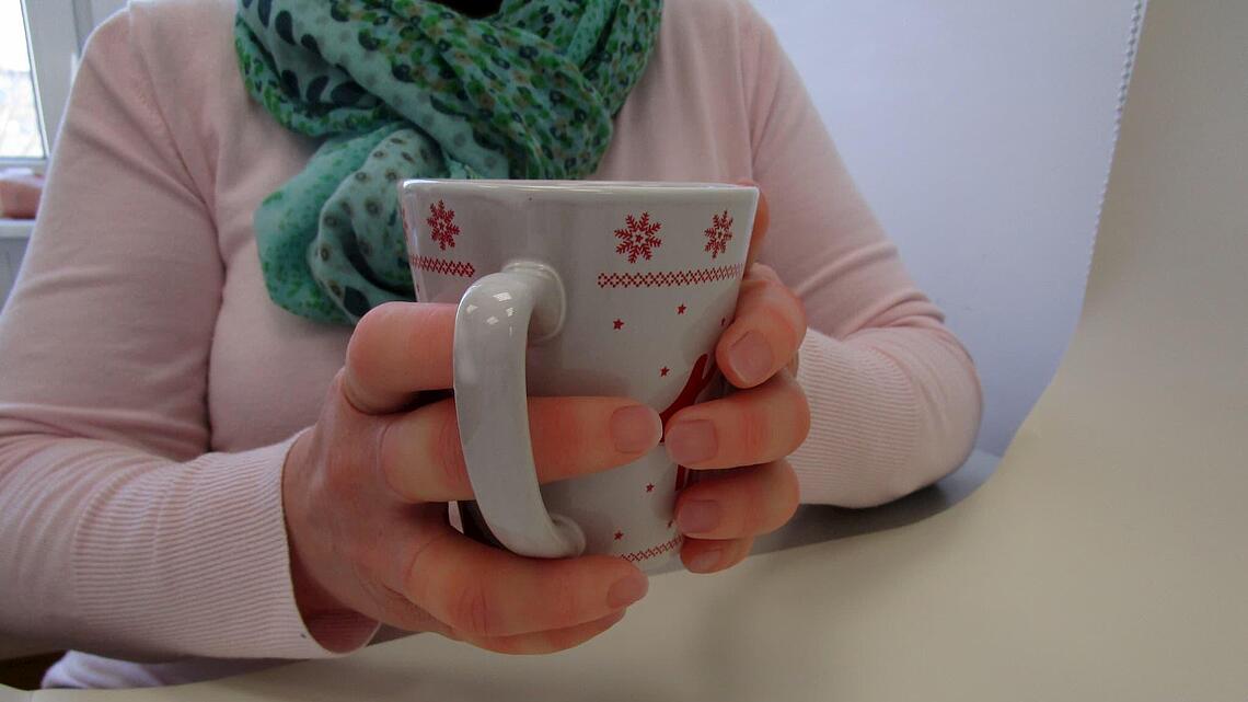 Tasse halten mit Silikon-Fingerprothesen Hand mit Silikon-Fingerprothesen, die eine Tasse hält