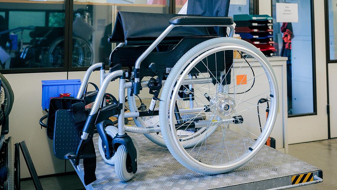 Rollstuhl auf Hebebühne Rollstuhl steht in der Werkstatt auf einer Hebebühne