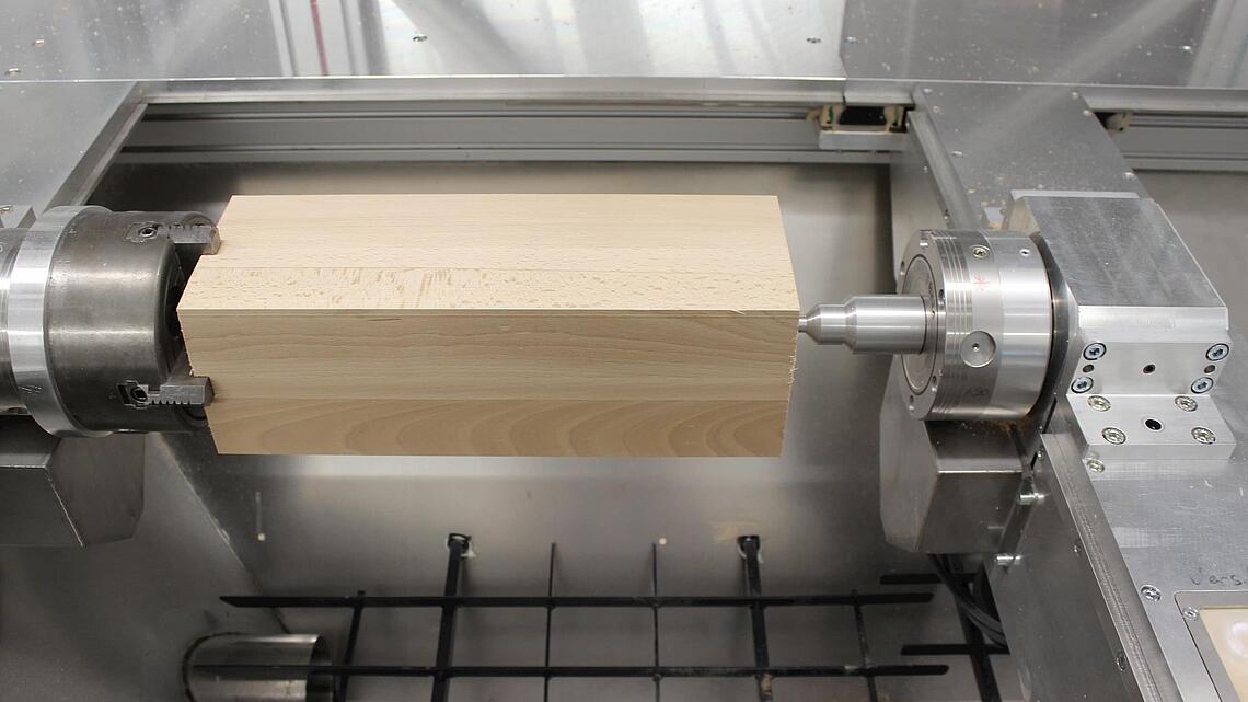 Holzblock als Rohmaterial für die Fräsmaschine in der Fräsmaschine eingespannter Holzblock als Rohmaterial