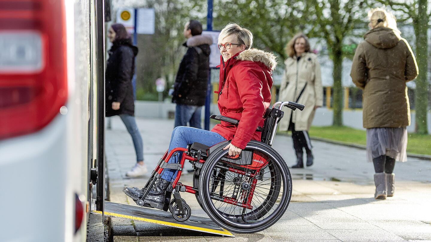 Frau im Rollstuhl auf Busrampe, © Ottobock Frau im Rollstuhl fährt über eine Rampe in einen Bus, © Ottobock