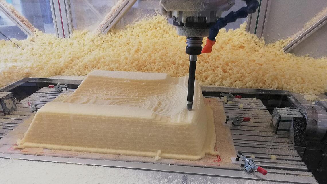 Fräsung einer Sitzschale aus Schaumstoff aus einem Schaumstoffblock wird eine Sitzschale gefräst