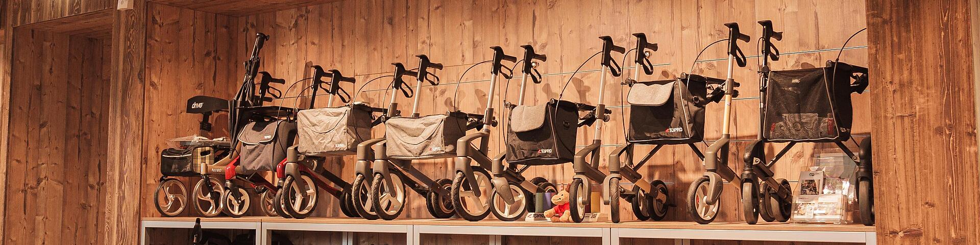 Ausstellung von Rollatoren mehrere Rollatoren an einer Wand in der Ausstellung zum Anschauen und Testen