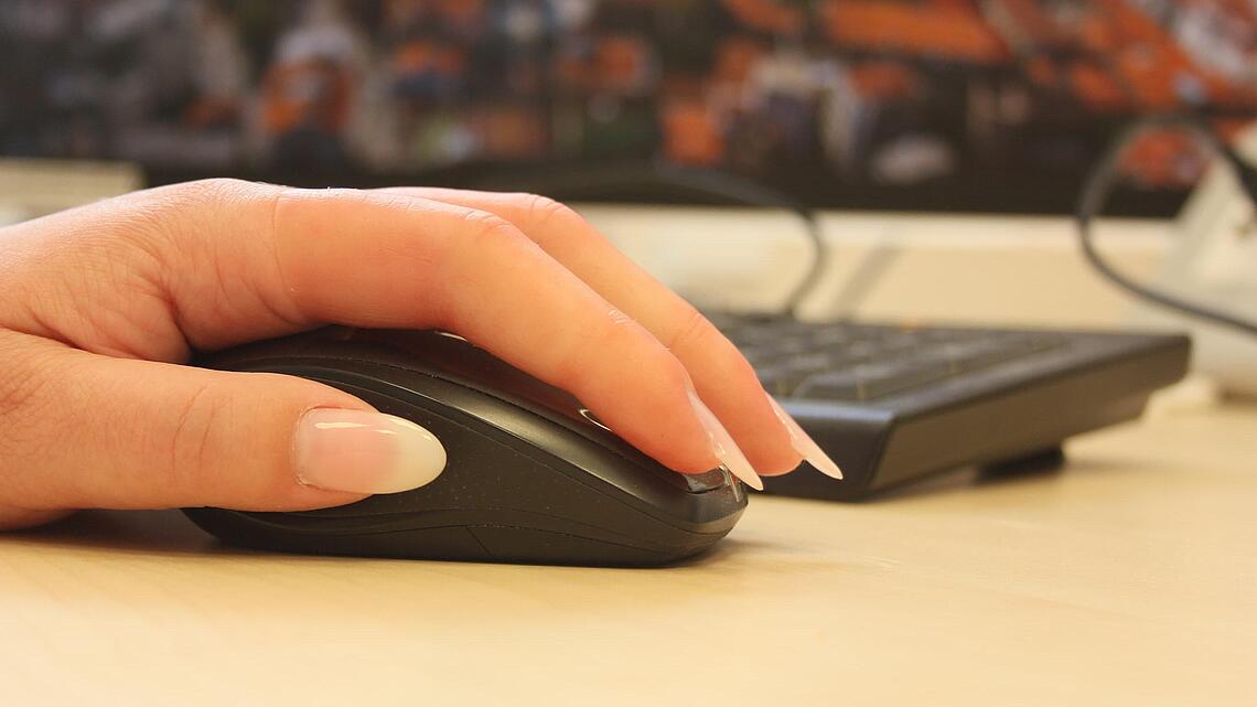 Fingerprothesen aus Silikon auf Computer-Maus Hand mit zwei Fingerprothesen aus Silikon auf einer Computer-Maus